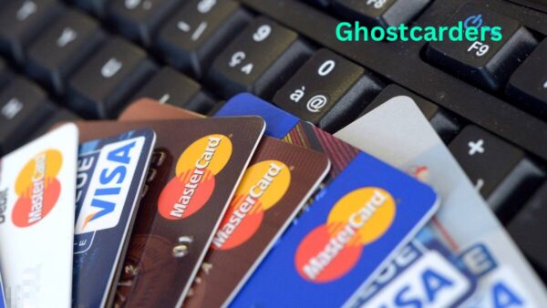 "Three credit cards laid out in a row with a magnifying glass over one, illustrating different methods of carding such as dumps, CVV, and BIN attacks."